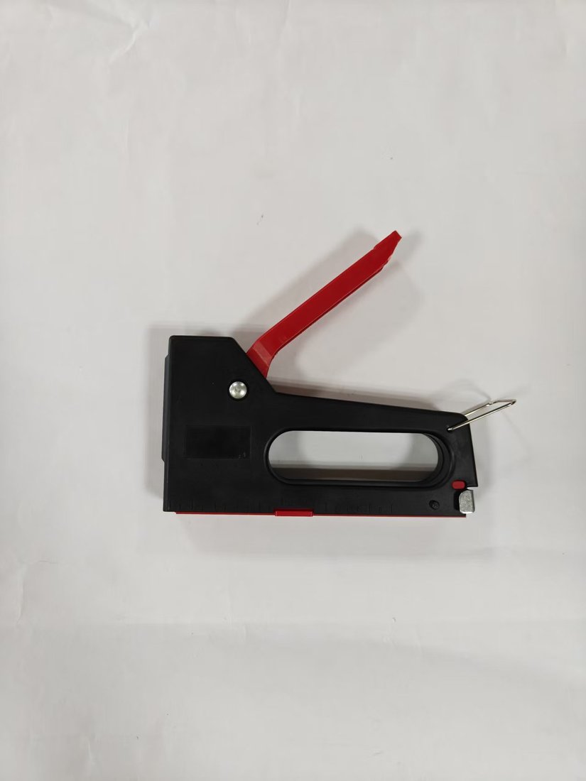 Plastic-body staple gun held in one hand with staples